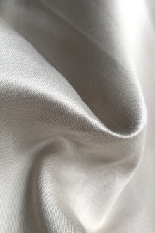 ivory satin is scrunched up to show texture and sheen