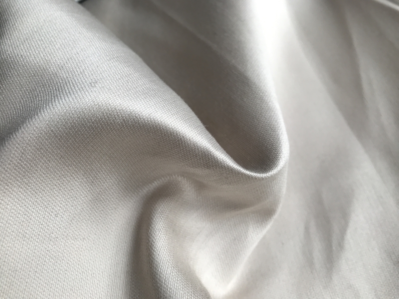 ivory satin is scrunched up to show texture, sheen, and weight
