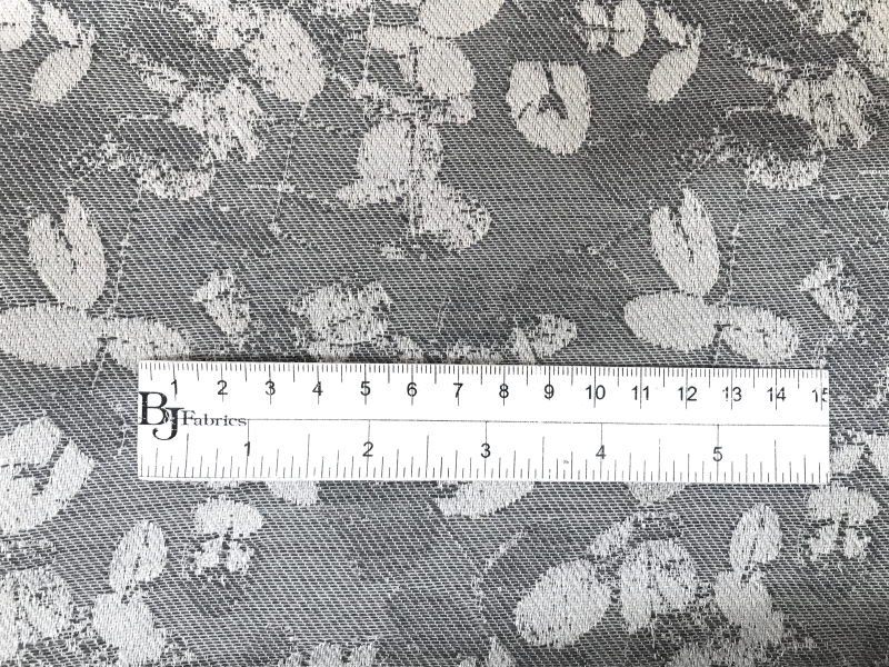 silver cotton and acetate blend jacquard with scattered leaves pattern with ruler to show scale