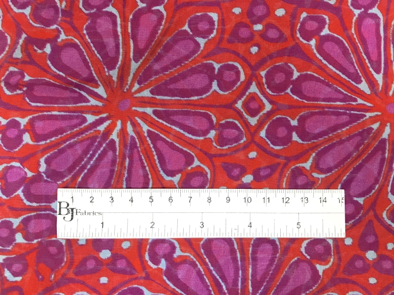 bright red silk chiffon with printed purple floral bursts with ruler to show scale